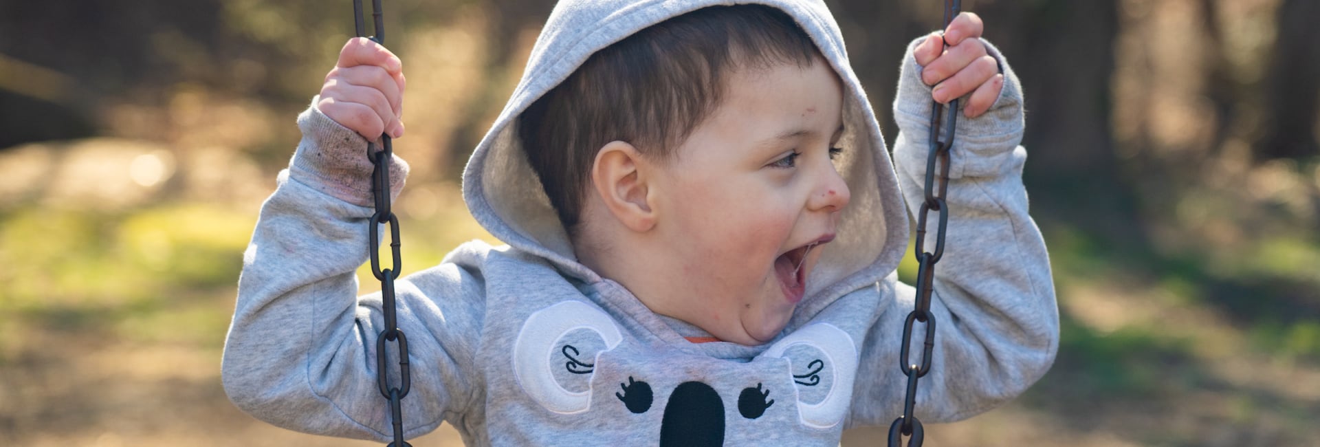 Un niño sonríe mientras se balancea en un columpio