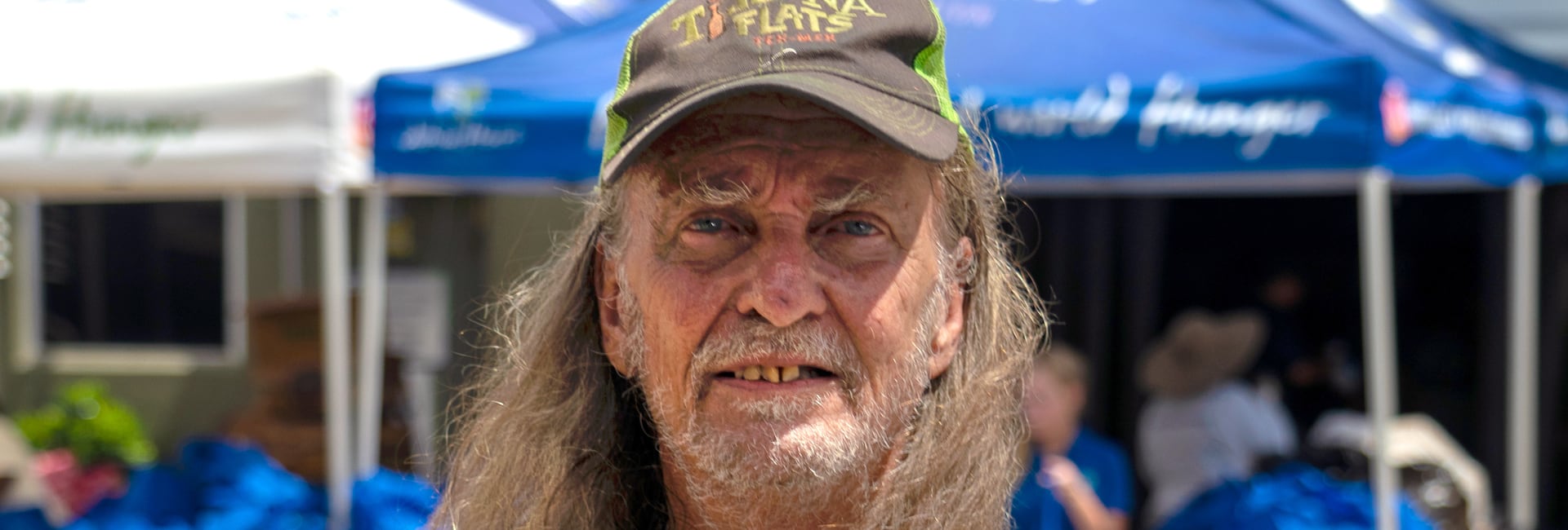 Un hombre sonriendo al aire libre en un evento