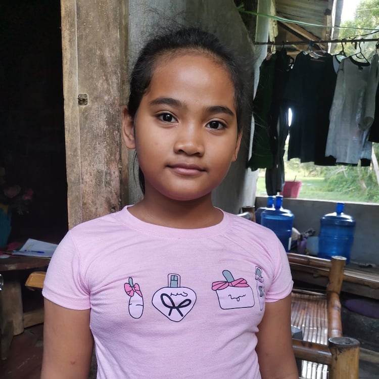 Niño con camisa rosa de pie en el interior