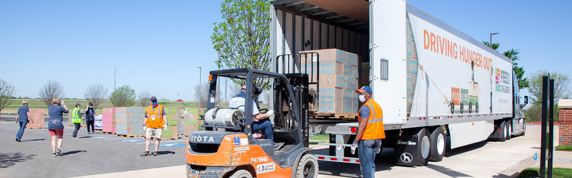 Una carretilla elevadora cargando cajas en un semirremolque de "feed the children".