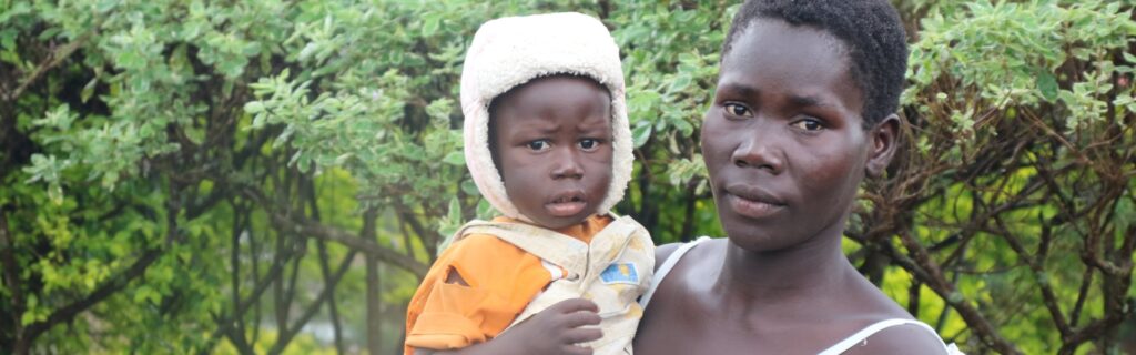 Una madre sostiene a su hijo al aire libre en África