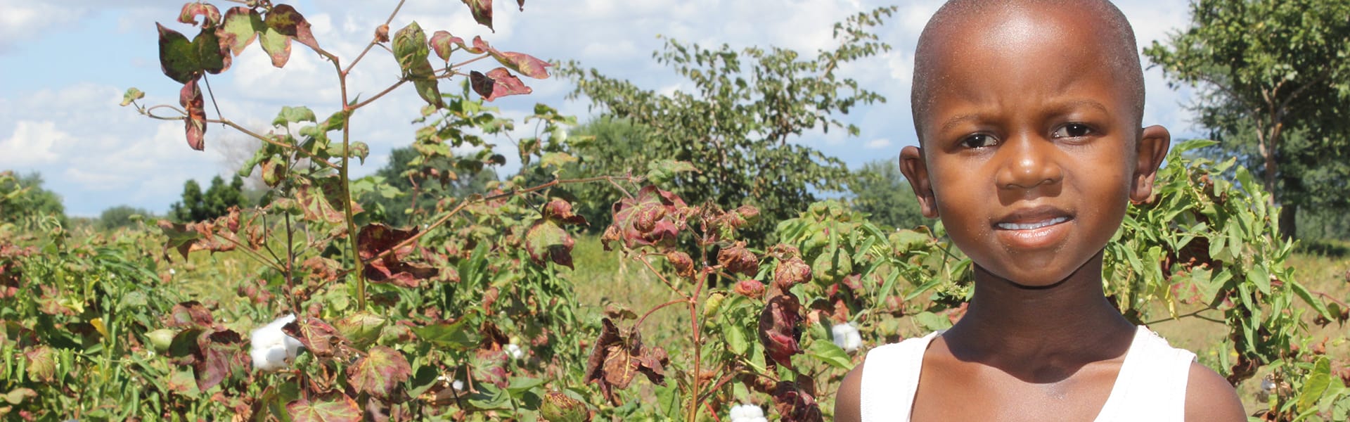 Una joven de pie al aire libre frente a un campo
