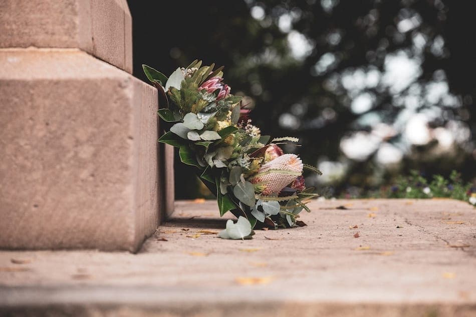 About us box delivery events A wreath of flowers sitting against bricks