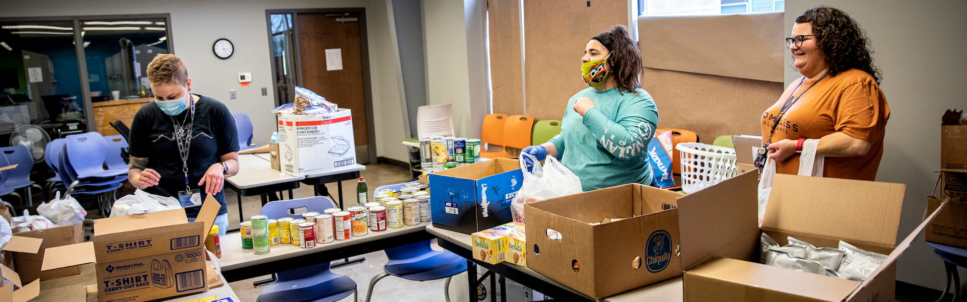 Un grupo de personas llenando cajas con alimentos