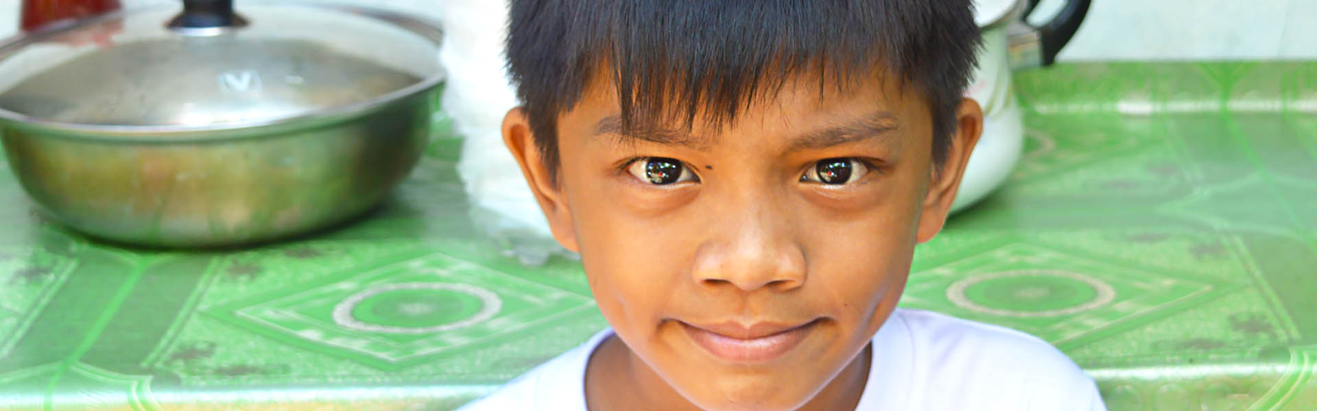 Un niño sentado junto a una mesa en Filipinas