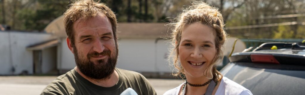 Un hombre y una mujer sonriendo al aire libre