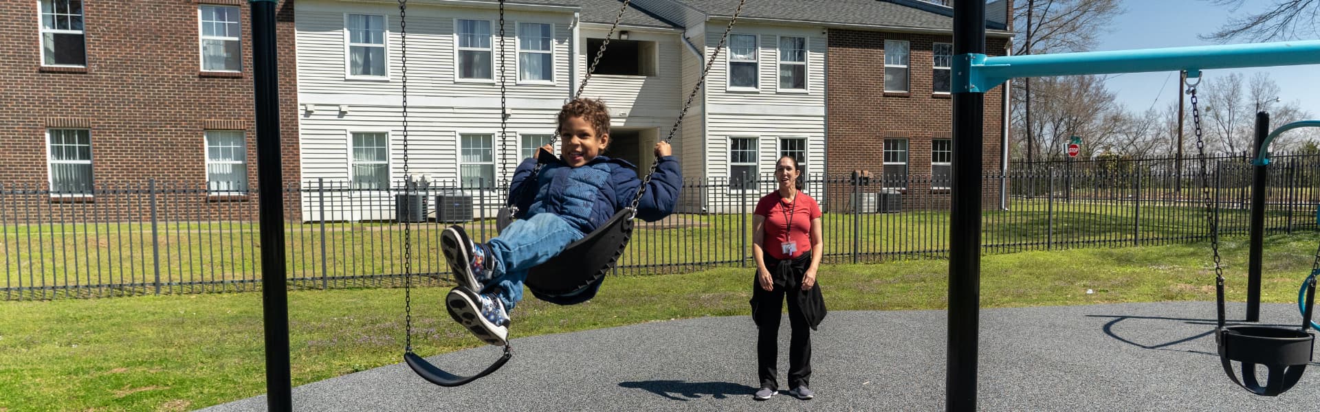 Un niño columpiándose en un columpio con su madre