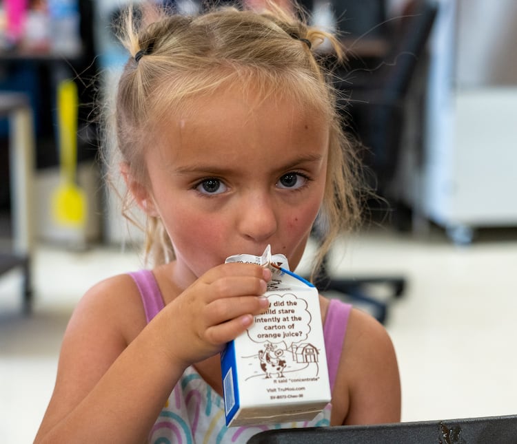 Un niño bebiendo leche dentro de casa